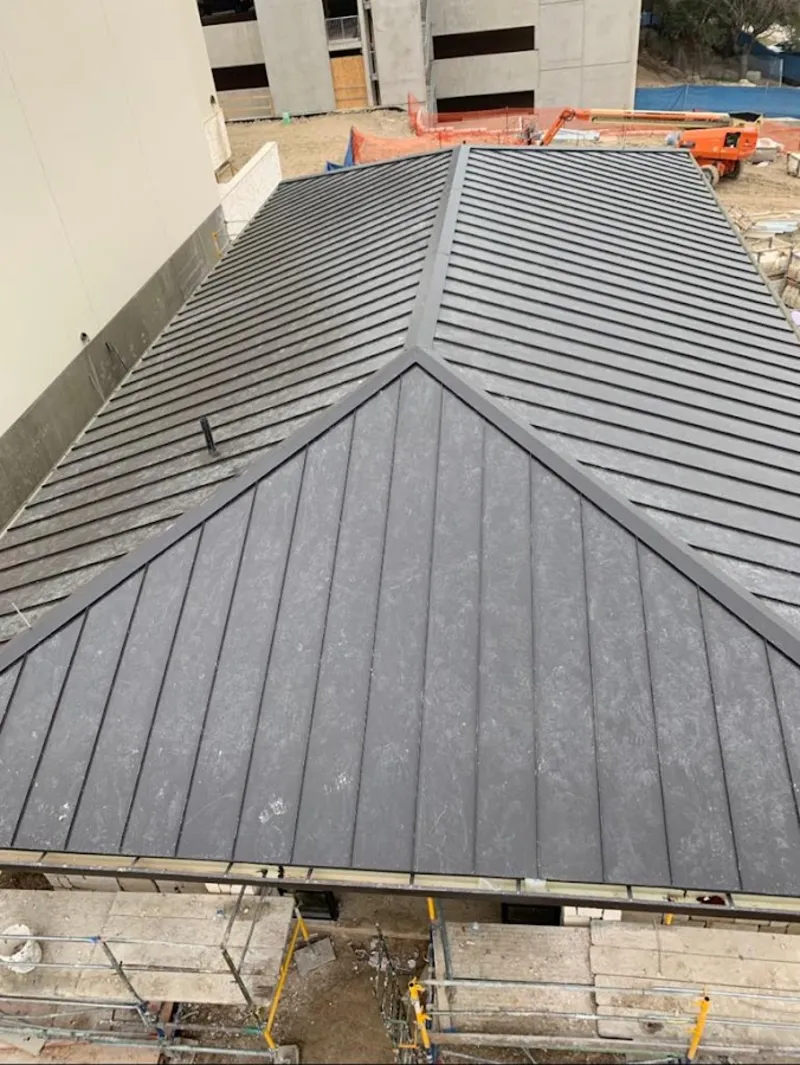 Commercial metal roof construction with crane equipment in Gladstone